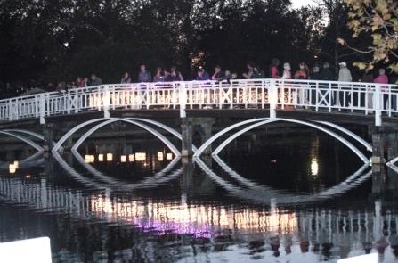 people are standing on the bridge over the water