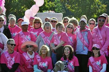 a group of women in pink shirts and hats