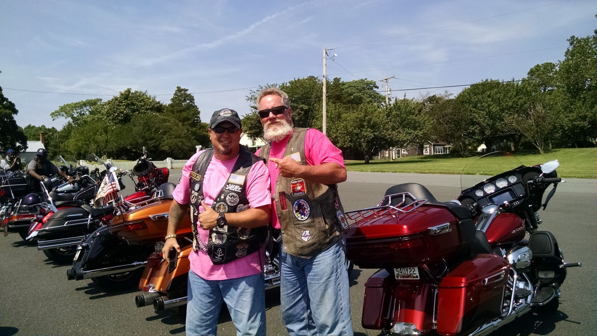 two men standing next to each other in front of motorcycles
