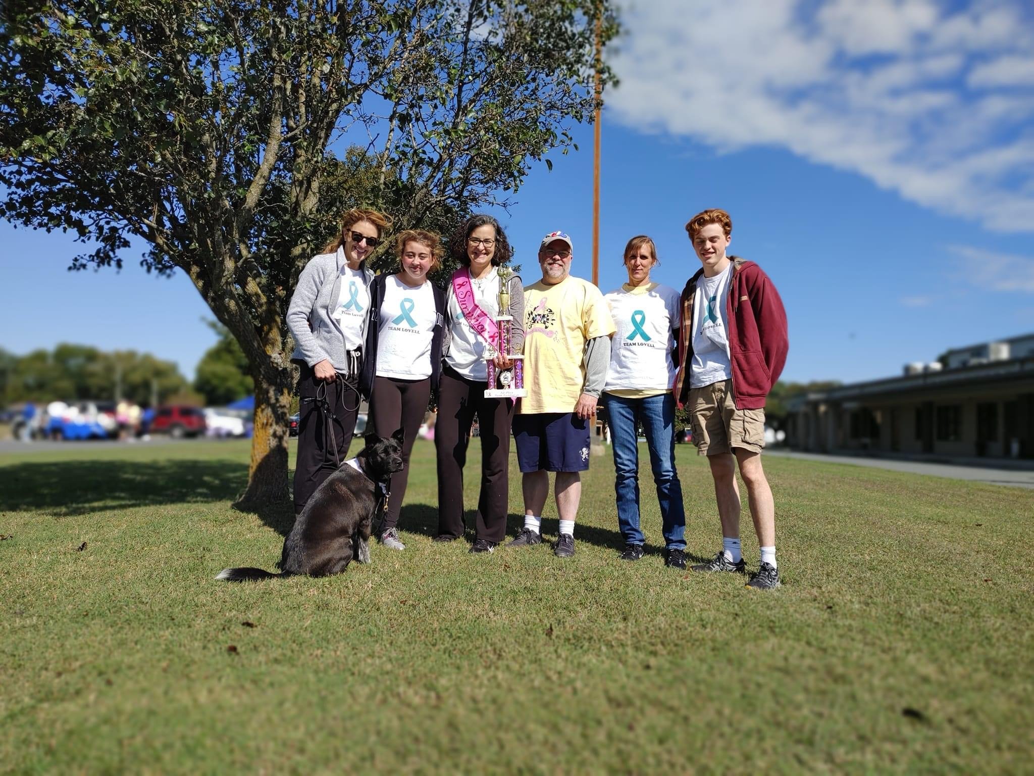 a group of people standing next to a dog