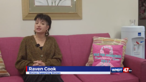 a woman sitting on a pink couch in a living room